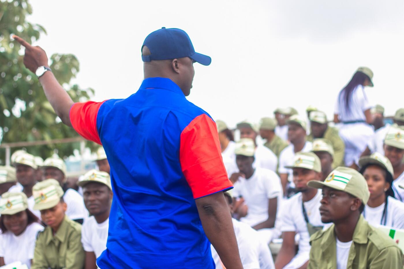 Facilitator addressing corps members at an orientation camp